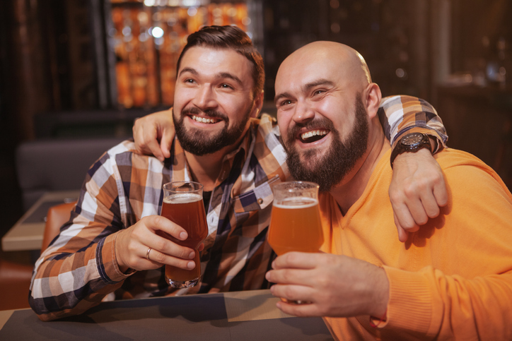 two bearded men drinking beer at the pub