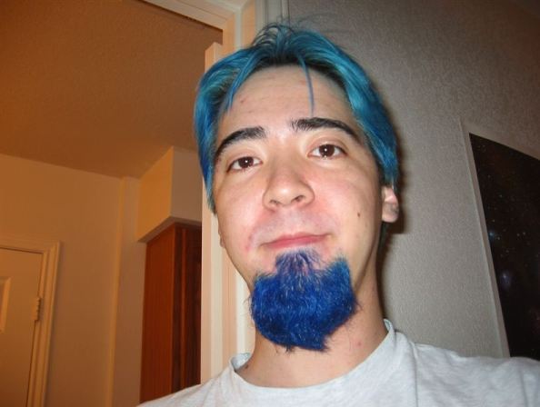 A man covering his hair in blue color completely.