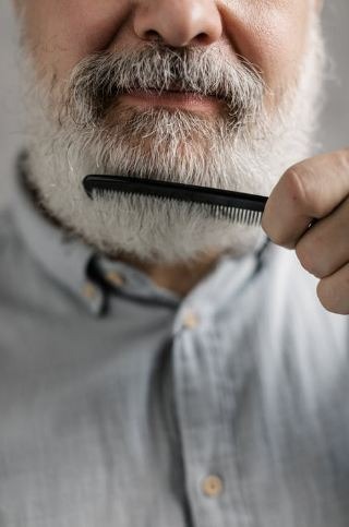 Elderly Man Combing His Beard