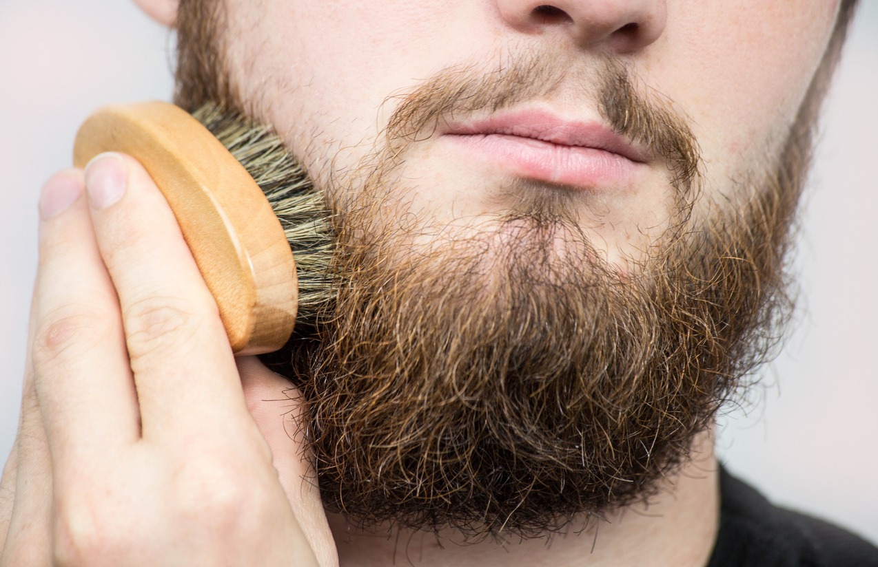 Hand of barber brushing beard. Barbershop customer,front view. Beard grooming tips for beginners.