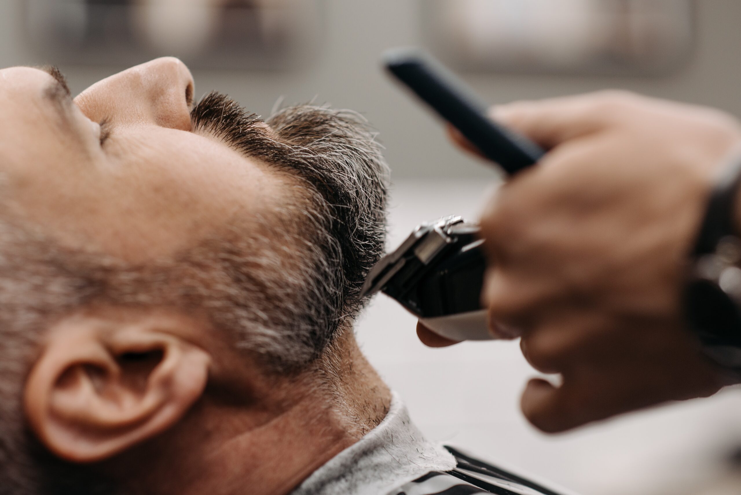 a barber cutting a clients beard