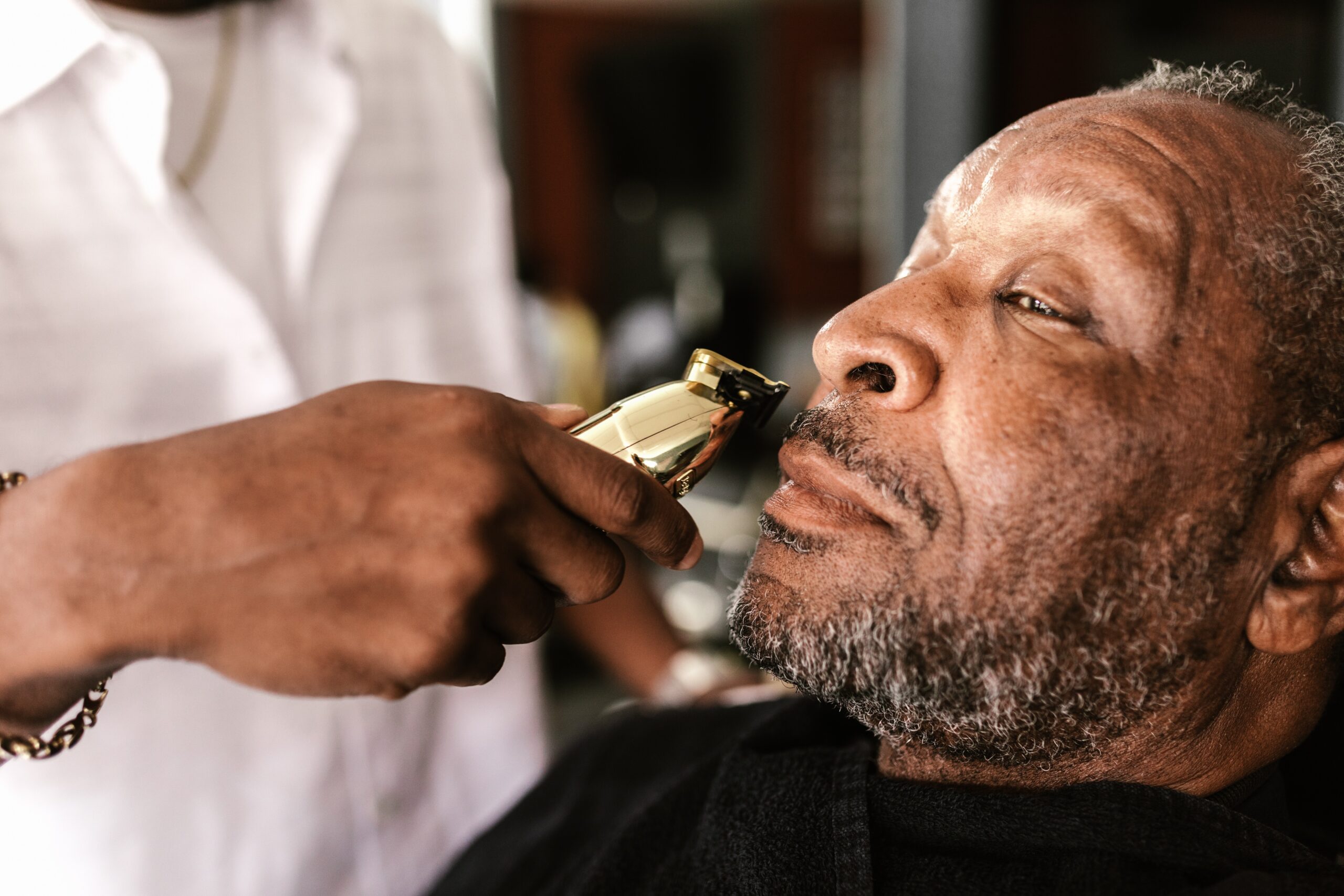 photo of a man getting his beard shaved